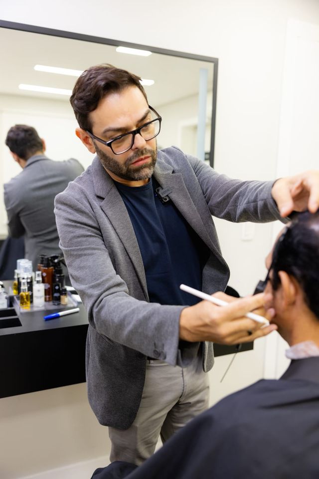 Dr. Wallace Alves desenhando a linha frontal de um paciente em consulta